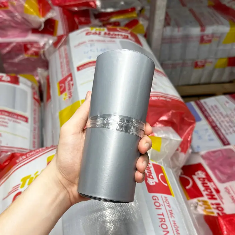 Cuộn túi niêm phong màu bạc cầm trên tay, chụp tại kho Túi Gói Hàng VN