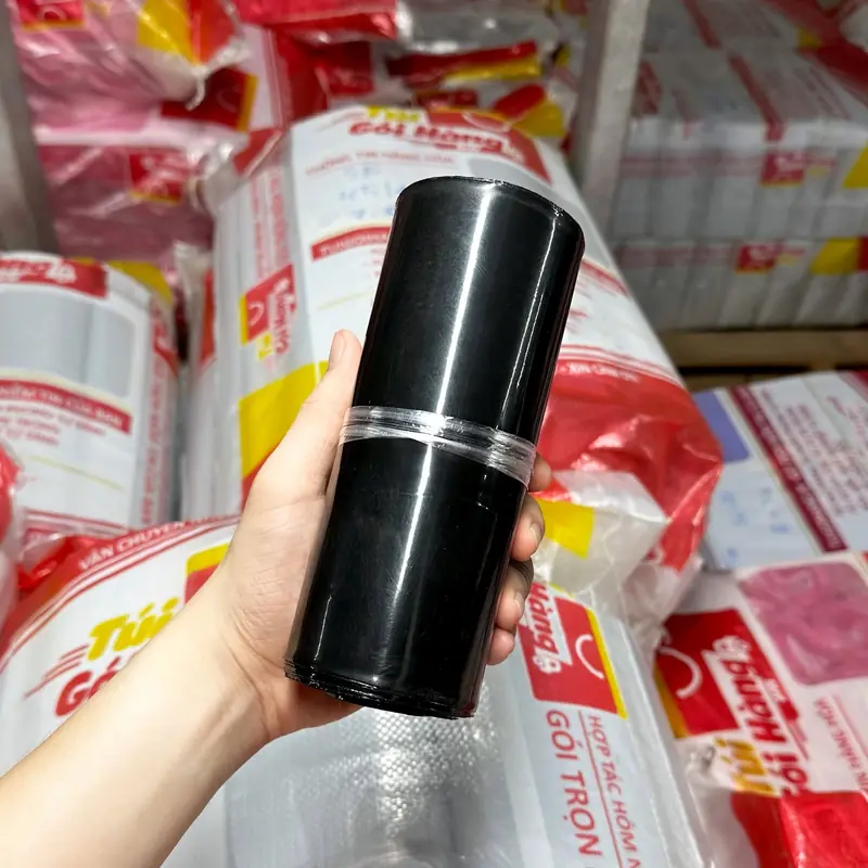 Cuộn túi niêm phong màu đen plus cầm trên tay, chụp tại kho Túi Gói Hàng VN