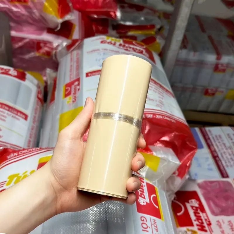 Cuộn túi niêm phong màu nâu sữa cầm trên tay, chụp tại kho Túi Gói Hàng VN
