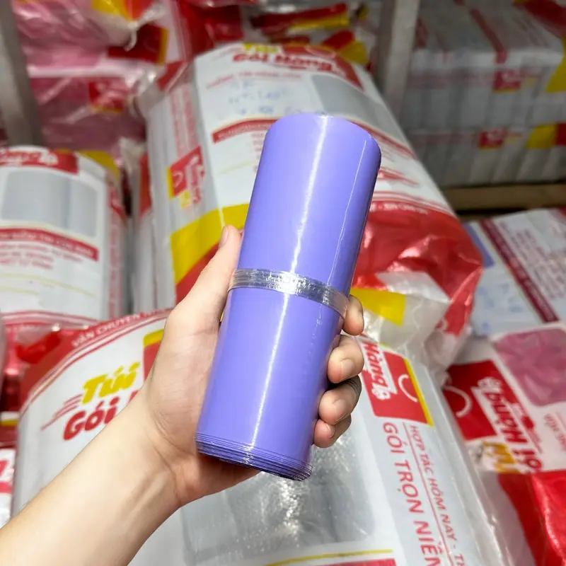 Cuộn túi niêm phong màu tím cầm trên tay, chụp tại kho Túi Gói Hàng VN
