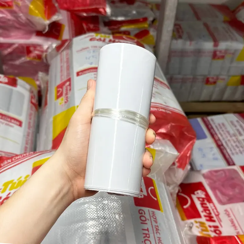 Cuộn túi niêm phong màu trắng sứ cầm trên tay, chụp tại kho Túi Gói Hàng VN
