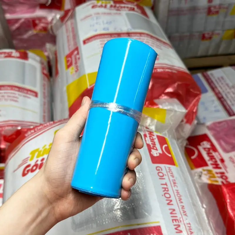 Cuộn túi niêm phong màu xanh dương cầm trên tay, chụp tại kho Túi Gói Hàng VN