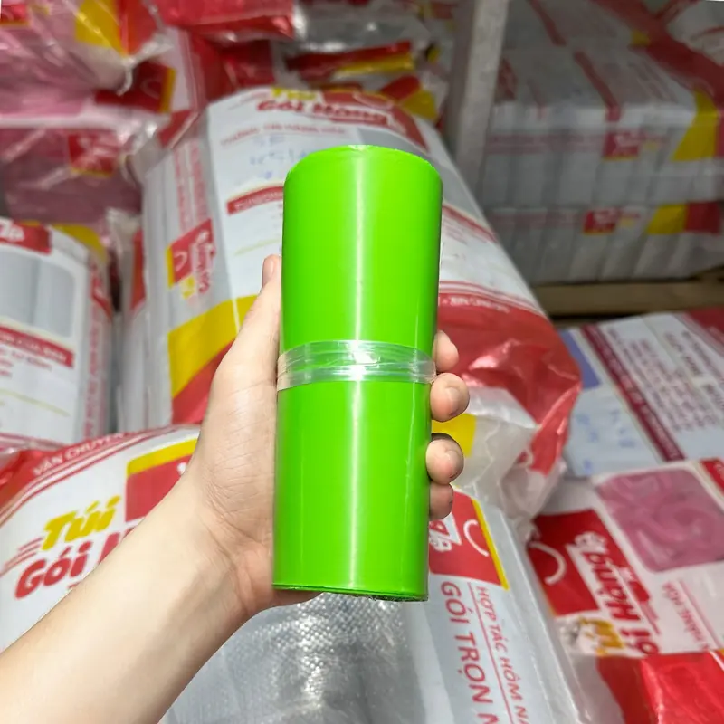 Cuộn túi niêm phong màu xanh lá sáng cầm trên tay, chụp tại kho Túi Gói Hàng VN
